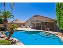 Backyard pool with palm trees, lounge chairs, and a shaded patio area for outdoor entertaining at 343 S Cottonwood St, Chandler, AZ 85225