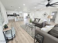Spacious living room with hardwood floors, ceiling fan, and comfortable seating area at 6607 S Mitchell Dr, Tempe, AZ 85283
