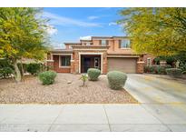 Charming two-story home featuring a stone facade, two-car garage, and professionally landscaped front yard at 12172 W Davis Ln, Avondale, AZ 85323