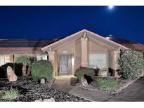 Charming home featuring a tiled roof, solar panels, and a well-manicured front yard at night at 17211 N 58Th St, Scottsdale, AZ 85254