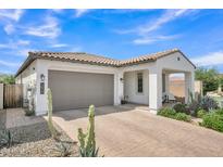 Charming single-story home featuring a tile roof, stucco exterior, and brick-paved driveway and walkway at 1876 S Huish Dr, Gilbert, AZ 85295