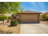 Tan two-car garage with stone accents and a well-maintained desert landscape at 22191 W Tonto St, Buckeye, AZ 85326
