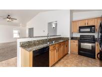 Open kitchen features granite countertops, stainless sink, and modern black appliances at 2433 W Hayden Peak Dr, San Tan Valley, AZ 85144
