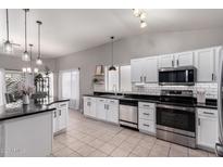 Bright kitchen features white cabinets, stainless steel appliances, black countertops, and tile flooring at 4109 E Chambers St, Phoenix, AZ 85040