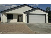 Inviting single story home featuring a two-car garage, gravel landscaping, and modern black trim at 4116 E Park St, Phoenix, AZ 85042