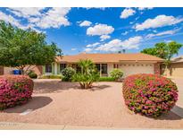 Charming home featuring manicured landscaping, flowering bushes, and a well-maintained two-car garage at 4232 W Purdue Ave, Phoenix, AZ 85051