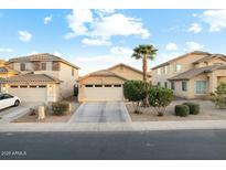 Charming single-Gathering home with a well-manicured front yard, a two-car garage, and a desert landscape at 44355 W Oster Dr, Maricopa, AZ 85138