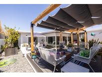 Inviting backyard with multiple seating areas, mature landscaping, and a pergola for shade at 6314 N 14Th St, Phoenix, AZ 85014