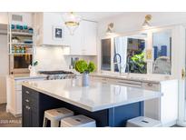 Bright kitchen showcasing white cabinets, marble countertops, stainless steel appliances and a large window over the sink at 6314 N 14Th St, Phoenix, AZ 85014