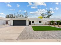 Charming single-story home with manicured lawn, dark garage door, and gravel landscaping at 6351 E Waltann Ln, Scottsdale, AZ 85254