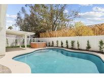 Backyard featuring a sparkling pool, hot tub, covered patio, and lush landscaping offers a private oasis for relaxation and recreation at 6351 E Waltann Ln, Scottsdale, AZ 85254