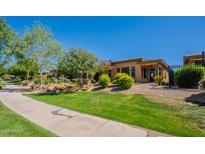 Charming home featuring a well-manicured lawn, colorful shrubbery, and an inviting front patio, all under a clear blue sky at 650 E Myrtle Pass, Queen Creek, AZ 85140