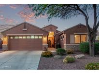 Charming single-story home with a well-manicured front yard and a two-car garage at dusk at 766 E Taylor Trl, San Tan Valley, AZ 85143