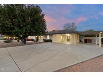 Inviting single-story home with a covered parking area, mature landscaping, and a large driveway at 8228 E Oak St, Scottsdale, AZ 85257
