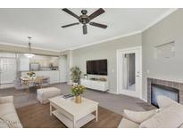 Open-concept living room features a fireplace, ceiling fan, and access to the kitchen at 19777 N 76Th St # 3238, Scottsdale, AZ 85255