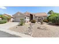 Charming home featuring desert landscaping, a two-car garage, and a classic southwestern-style facade with a tile roof at 3021 N 148Th Dr, Goodyear, AZ 85395