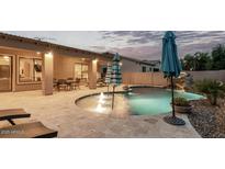 Backyard pool area with rock waterfall, patio, seating, and a view of the home's exterior at 3170 E Lynx Pl, Chandler, AZ 85249