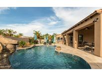 Backyard with inviting pool area, patio, playground, waterfall feature, and meticulous landscaping at 3170 E Lynx Pl, Chandler, AZ 85249