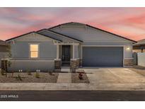 Charming single-story home with a well-manicured front yard and a two-car garage at 37111 W Parador Ln, Maricopa, AZ 85138