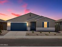 Beautiful single-story home featuring a blue garage door and complementary stone landscaping at 37151 W Parador Ln, Maricopa, AZ 85138