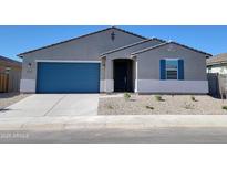 Charming single-story home with a blue garage door, stone accents, and desert landscaping at 37151 W Parador Ln, Maricopa, AZ 85138