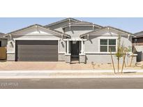 Charming single-story home featuring a grey exterior, brick accents, and a well-maintained front yard at 4032 S 176Th Dr, Goodyear, AZ 85338