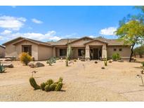 Charming desert landscaping adorns the front yard of this home with stucco exterior and covered porch at 5744 E Hedgehog Pl, Scottsdale, AZ 85266
