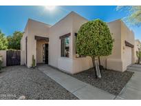 Front entrance and walkway with desert landscaping including cacti and decorative trees at 15148 N 100Th Pl, Scottsdale, AZ 85260