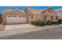 Tan single-Gathering home with a two-car garage, well-maintained landscaping, and a paved driveway at 2039 W Ronald Rd, Phoenix, AZ 85029