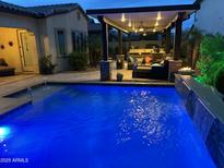 Backyard pool with a covered outdoor living space and a water feature offers an oasis for relaxation and entertainment at 2087 N Park St, Buckeye, AZ 85396