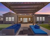Stunning backyard featuring a pergola, outdoor seating, and well-maintained artificial grass at 3466 E Hazeltine Way, Queen Creek, AZ 85142