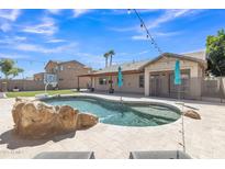 Resort-style backyard featuring a sparkling pool with rock accents, lush landscaping, and ample space for outdoor entertaining at 4968 E Westchester Dr, Chandler, AZ 85249