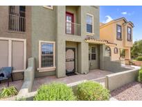 Townhouse features a private gated front patio with stone tiling and landscaped shrubs at 6710 E University Dr # 133, Mesa, AZ 85205