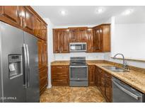Modern kitchen features stainless appliances, granite counters, and wood cabinetry at 6710 E University Dr # 133, Mesa, AZ 85205