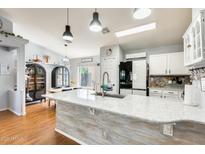 Modern kitchen featuring a spacious island with granite countertop and stainless steel appliances, flowing into the dining area at 11822 W Softwind Dr, Sun City, AZ 85373