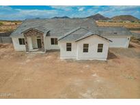 New construction home featuring a brick entryway, gray roof and white exterior at 9486 W Sandstone Mountain Dr, Casa Grande, AZ 85194