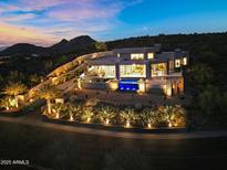 Stunning desert home with captivating pool and cascading waterfall under a colorful dusk sky at 13209 N 17Th Pl, Phoenix, AZ 85022