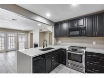 Modern kitchen featuring granite countertops, stainless steel appliances, and dark cabinetry at 30 E Brown Rd # 1048, Mesa, AZ 85201