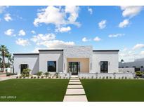 Striking modern home features white brick accents, clean lines, and lush green lawn at 6202 E Larkspur Dr, Scottsdale, AZ 85254