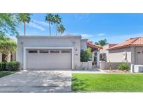 Charming home featuring a two-car garage, desert landscaping, and a clay tile roof under a sunny sky at 7917 E Cactus Wren Rd, Scottsdale, AZ 85250