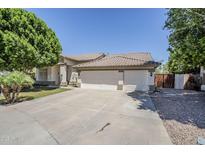 Charming single story home featuring a three car garage and desert landscaping at 1001 N Quail Ln, Gilbert, AZ 85233