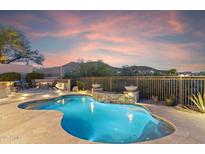 Backyard pool features a rock waterfall feature, built in fire pit, and desert views at 10811 E Acoma Dr, Scottsdale, AZ 85255