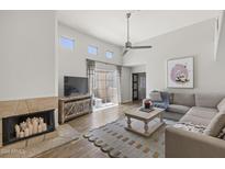 Bright living room features a fireplace, high ceilings, and a balcony with sliding glass doors at 11333 N 92Nd St # 2049, Scottsdale, AZ 85260