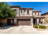 Inviting two-story home with a two-car garage, tile roof, and neatly landscaped front yard at 18484 W Westfall Way, Surprise, AZ 85374
