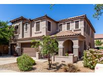Charming two-story home featuring a tile roof, arched entry, and a well-maintained landscaped front yard at 18484 W Westfall Way, Surprise, AZ 85374