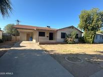 Charming single-story home with a covered carport, driveway, and a well-maintained yard at 1907 W Gardenia Dr, Phoenix, AZ 85021