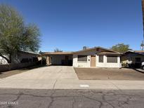 Single-story home with a covered carport, neutral color palette, and a large front yard at 2328 W Lupine Ave, Phoenix, AZ 85029