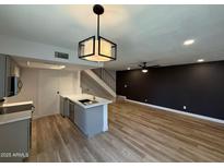 Open concept kitchen with gray cabinets, white countertop, and modern light fixture at 2625 W Ocotillo Rd # 4, Phoenix, AZ 85017