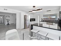 Bright, renovated kitchen features stainless steel appliances, modern lighting, and sleek black countertops at 3758 E Sunnyside Dr, Phoenix, AZ 85028