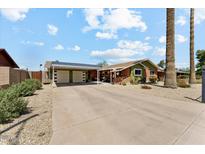 Charming single-story home featuring a covered two-car garage, desert landscaping, and a long concrete driveway at 4008 W Citrus Way, Phoenix, AZ 85019
